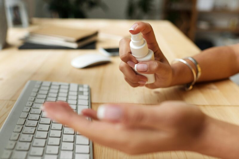 spraying cleaning agent on computer keyboard.